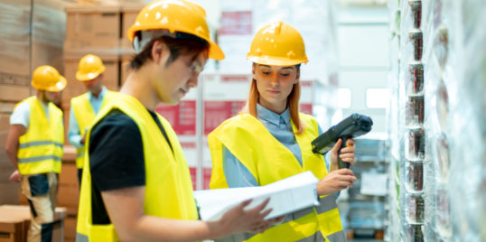 Workers in warehouse scanning packages KWLASNU